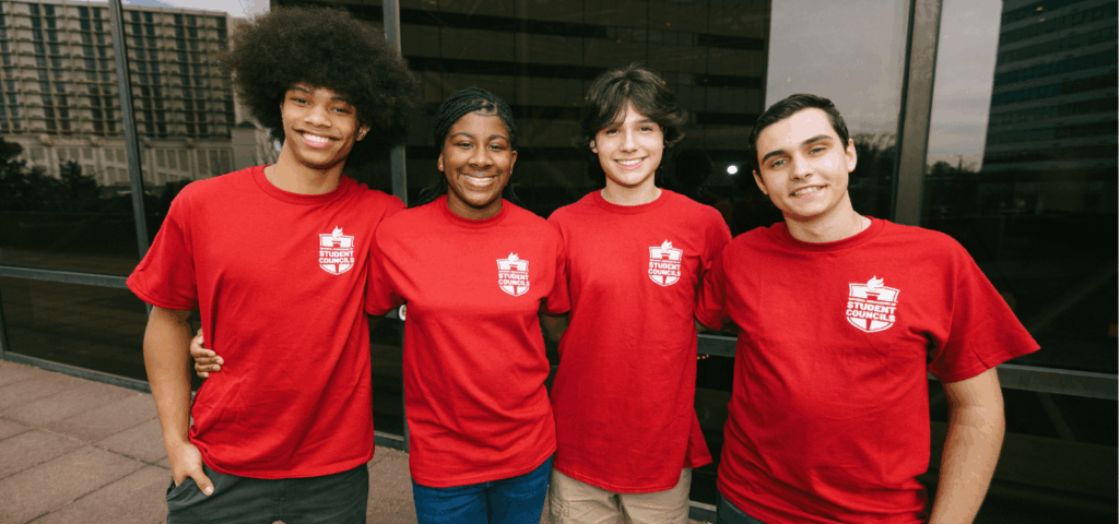 Group of NASC students in red shirts with their arms around each other